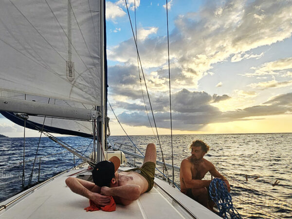 Sieste du le pont du bateau, face à un couché de soleil